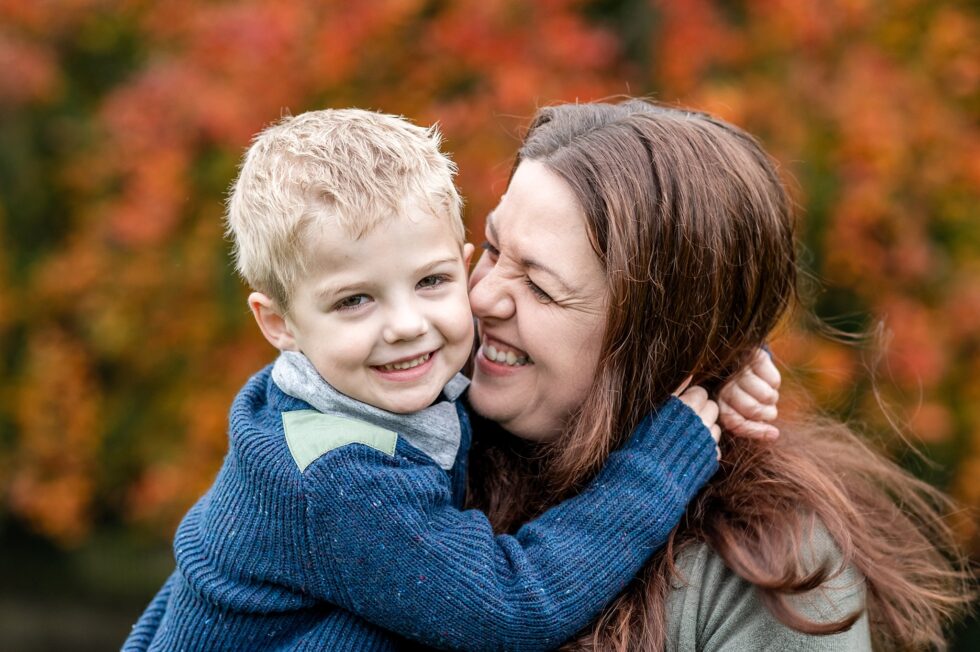Mum and son smiling during autumnal outdoor photography in Leeds, West Yorkshire
