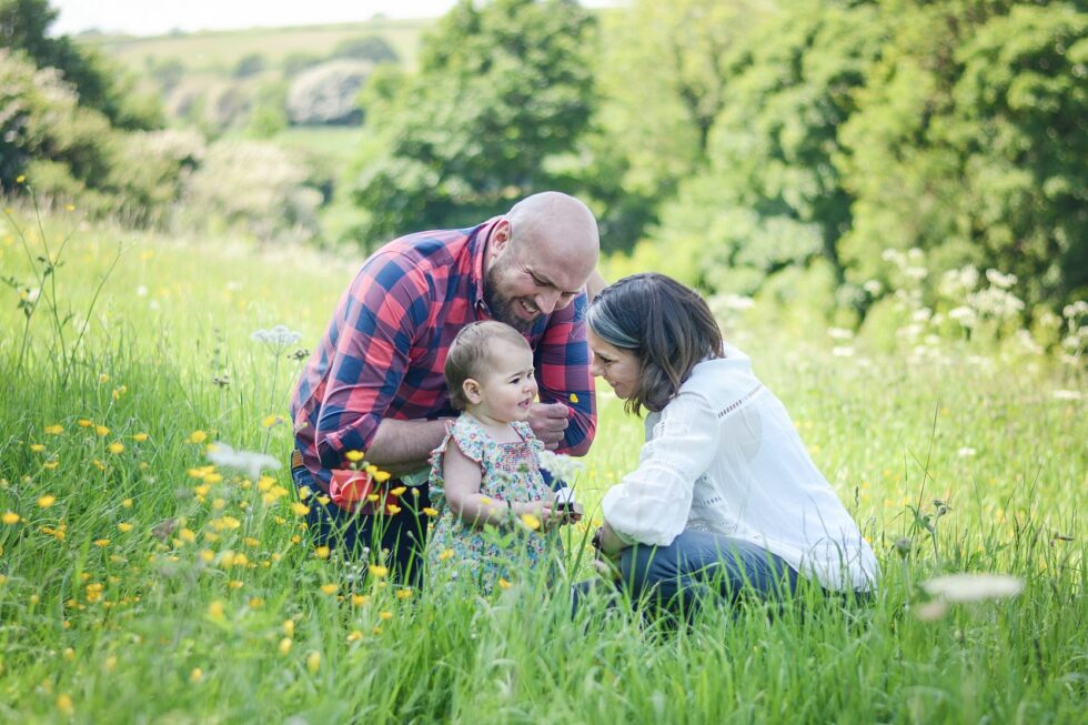 Family sitting in a field of wildflowers during an outdoor photography session in Skipton, North Yorkshire
