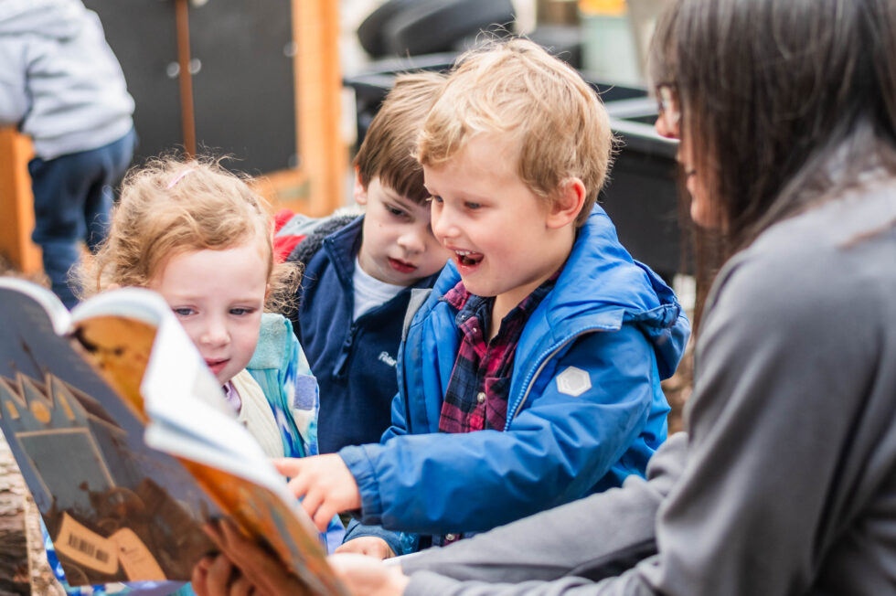 Teachers and children reading together in a classroom during a pre-school photography session for brochures in Ilkley, West Yorkshire