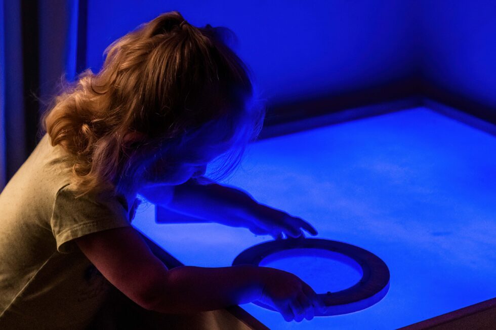 nursery pupil playing with light board in private day nursery in Yorkshire
